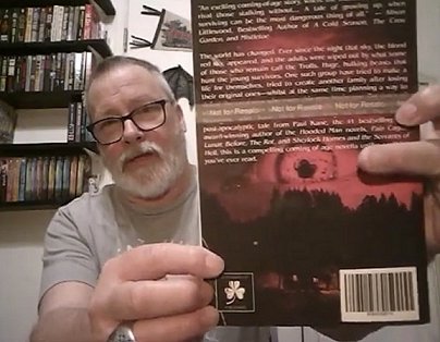 Reviewer showing back cover of Blood Red Sky by Paul Kane