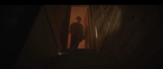 Man standing in open doorway at top of stairs
