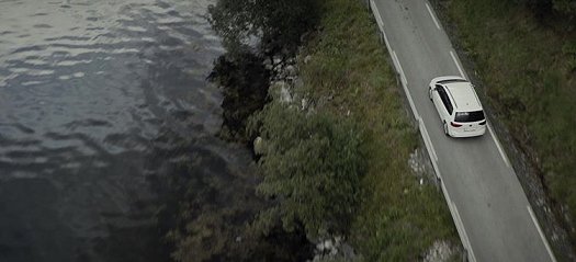 Still from the Colour of Madness - aerial shot of car by water