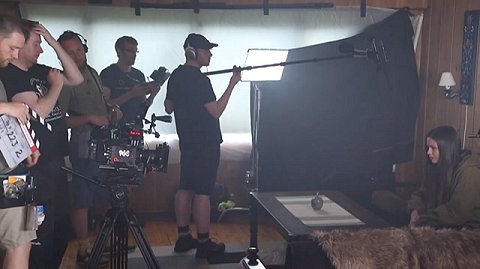 Behind the scenes shot - crew facing woman on sofa