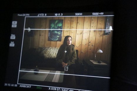 Screenshot of camera shot - young woman on sofa