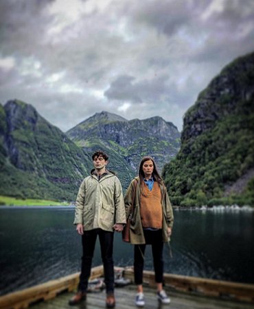 Man and pregnant woman standing on dock