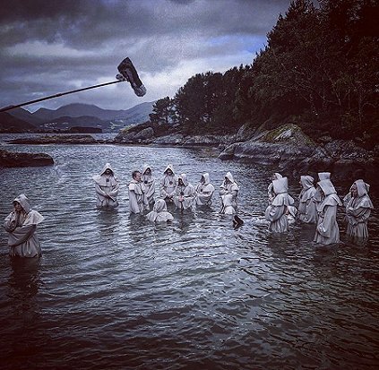 Hooded figures in water, boom mic in foreground