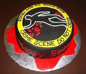 Image of cake decorated with a body outline, blood and crime scene tape saying Crime Scene Do Not Cross