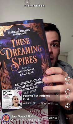 photograph of Joel Wood holding a copy of These Dreaming Spires, edited by Marie O'Regan and Paul Kane, up to the camera