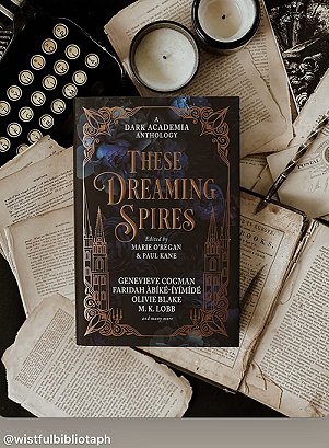 photograph showing a copy of These Dreaming Spires, edited by Marie O'Regan and Paul Kane, on a bed of loose pages from a book. Above this are two jar candles and a keyboard