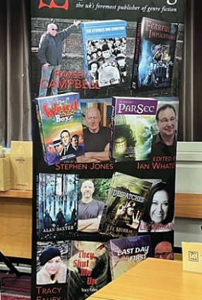 Photograph of PS Publishing's banner - featuring They Shut Me Up by Tracy Fahey, Despatches by Lee Murray, The Leaves Forget by Alan Baxter