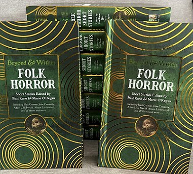 photograph showing two copies of Beyond & Within Folk Horror, edited by Paul Kane and Marie O'Regan, standing against a stack of seven other copies of the book