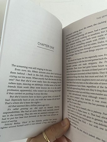 image of a man's hand holding a copy of The Gemini Effect, by Paul Kane, open to the beginning of Chapter One