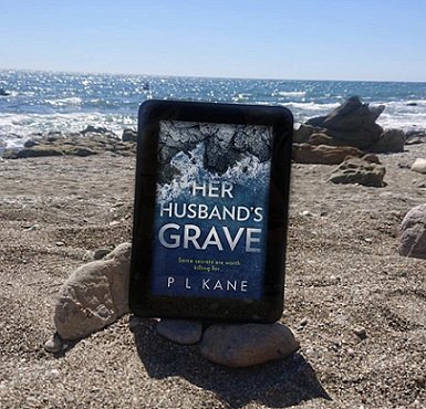 kindle on beach. Ebook of Her Husband's Grave by P L Kane