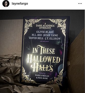 Screenshot - Layne Fargo shows a copy of In These Hallowed Halls, edited by Marie O'Regan and Paul Kane, on top of a cardboard box with brown tissue paper