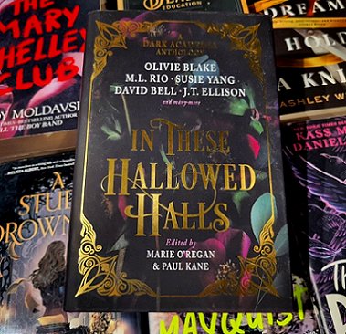 image of a copy of In These Hallowed Halls, edited by Marie O'Regan and Paul Kane, lying on top of a pile of other books