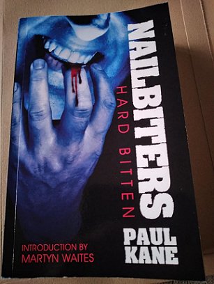 A copy of the book Nailbiters - Hardbitten, by Paul Kane, on a wooden surface