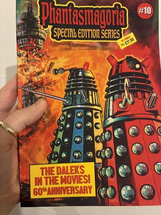 photograph showing a man's hand holding up a copy of the Special Daleks issue of Phantasmagoria magazine to show the front cover