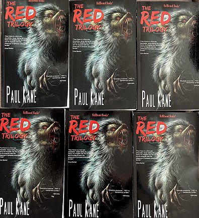 Display showing six copies of The RED Trilogy by Paul Kane. Black cover features a howling werewolf