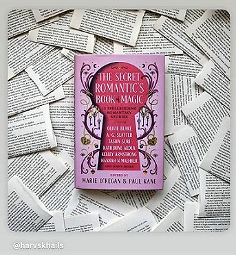 photograph of a copy of The Secret Romantic's Book of Magic, edited by Marie O'Regan and Paul Kane, lying on a bed of loose pages from books