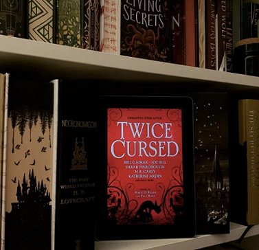 Picture of bookshelves, featuring a copy of Twice Cursed, edited by Marie O'Regan and Paul Kane