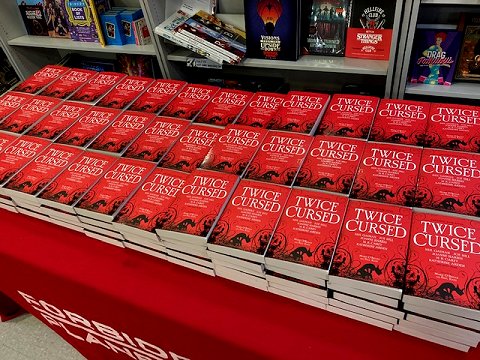 Table at Forbidden Planet displaying many copies of Twice Cursed, edited by Marie O'Regan and Paul Kane