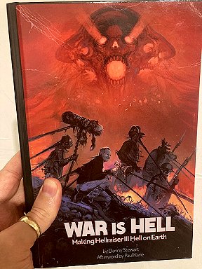 photograph of a man's hand holding a copy of War is Hell: Making Hellraiser III Hell on Earth