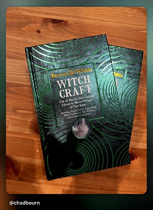 screenshot from @chadbourn. Photo shows two copies of Beyond and Within Witchcraft, edited by Marie O'Regan and Paul Kane, lying on a wooden surface