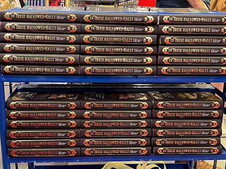 Image of a blue trolley holding rows of copies of In These Hallowed Halls, edited by Marie O'Regan and Paul Kane