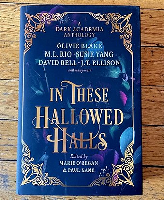 photograph of a copy of In These Hallowed Halls, edited by Marie O'Regan and Paul Kane, lying on wooden floorboards