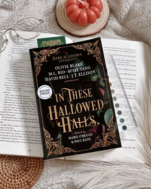 Display of a copy of In These Hallowed Halls, edited by Marie O'Regan and Paul Kane, lying on an open book, beside a ruler and a pair of glasses on a sheepskin cloth