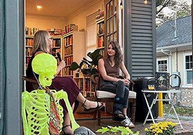 photograph of M L Rio sitting beside a blonde woman with a microphone outside a bookstore