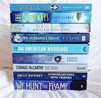 Book stack, including Her Husband's Grave by P L Kane